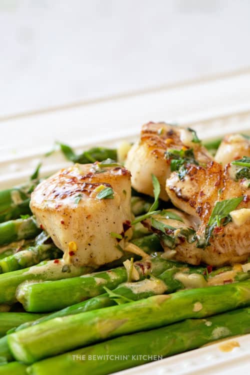 Pan Seared scallops over a bed of asparagus