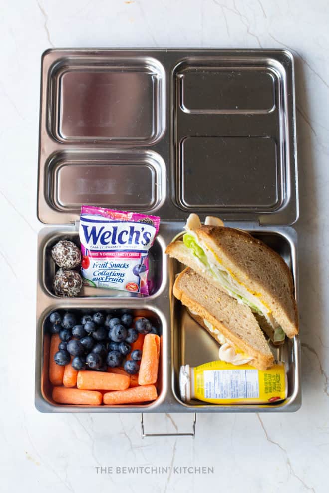 Energy bites, Welch's Fruit Snacks, blueberries, carrots, turkey sandwich on gluten free bread, drinkable yogurt in a PlanetBox bento box. #lunchideas