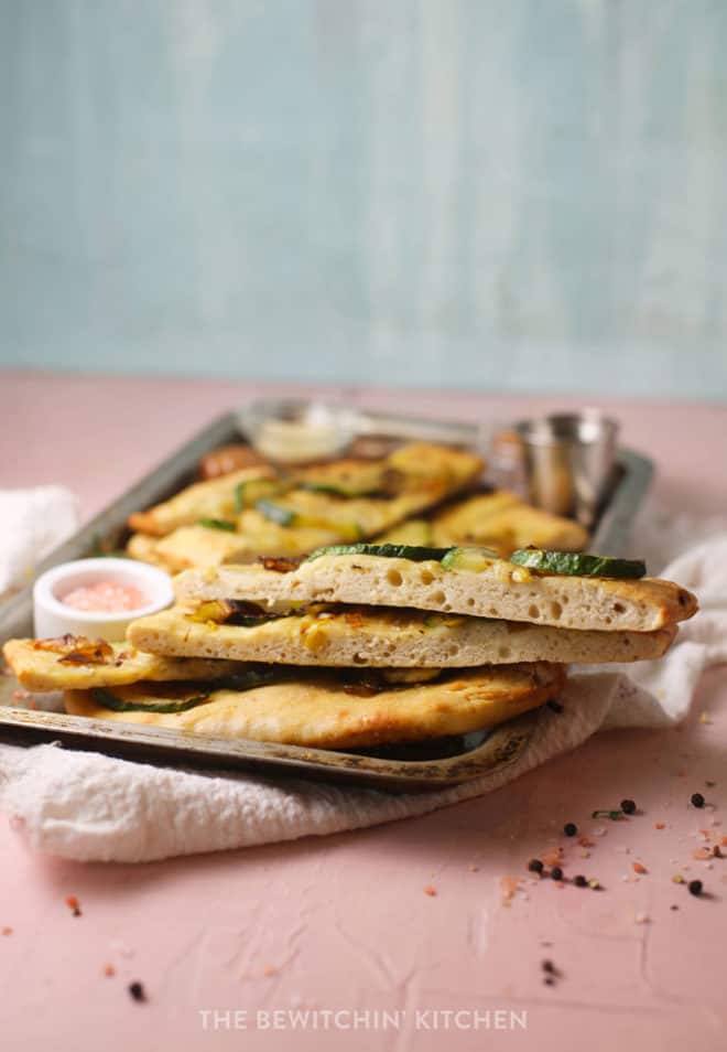 side view of sliced focaccia bread with sliced zucchini and pink sea salt