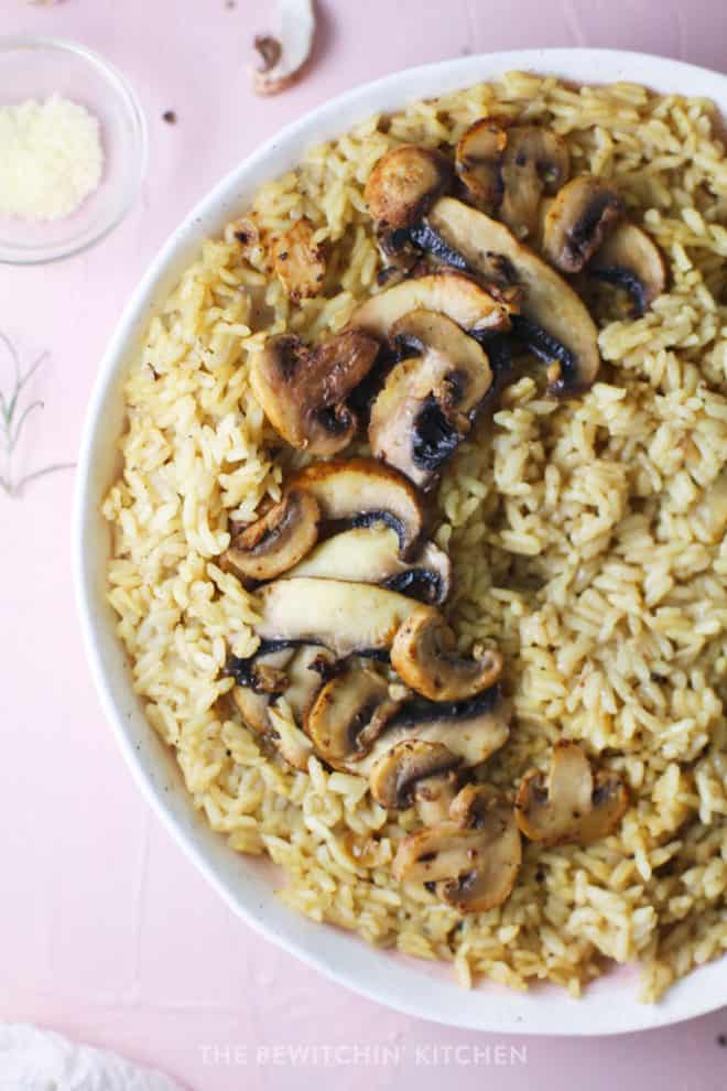 Risotto in a white dish with sliced mushrooms on top