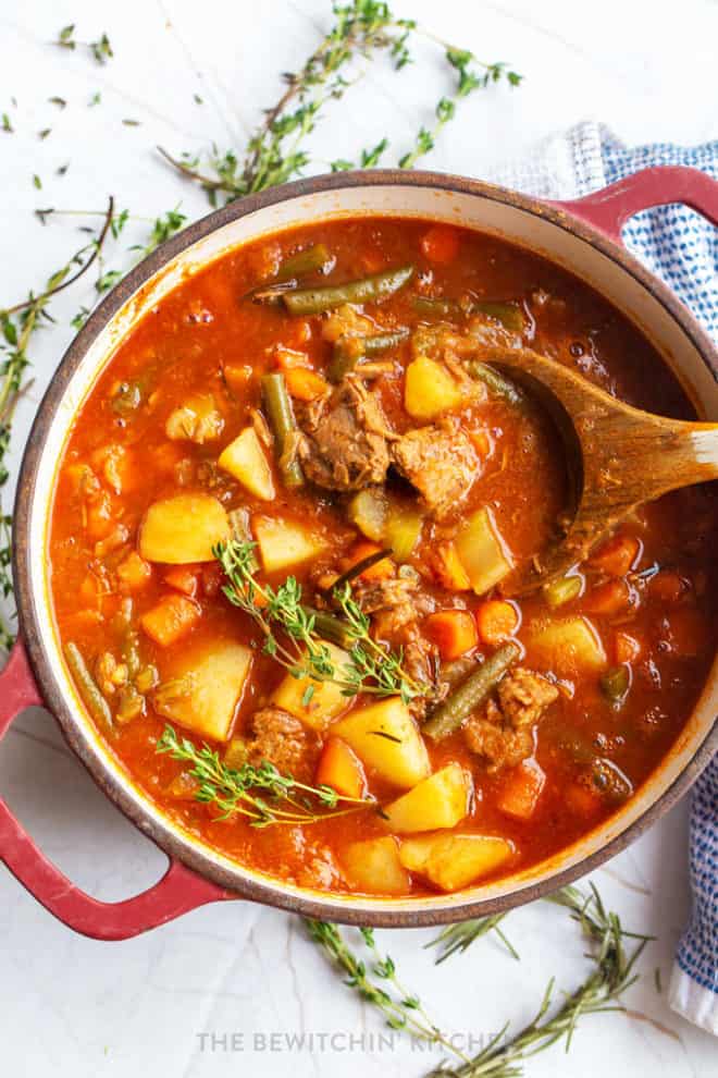 overhead view of healthy roast beef soup stirred with a wooden spoon