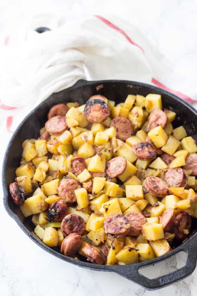 cooked chicken apple sausage with potatoes and apples in a cast iron skillet