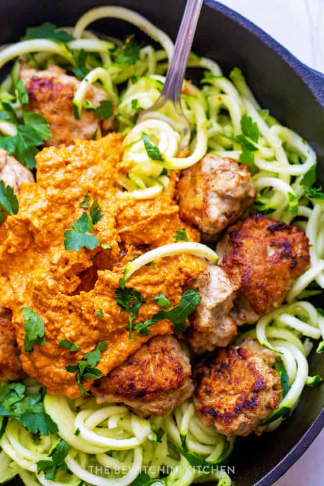 close up of a tasty romesco sauce over healthy chicken meatballs and zoodles