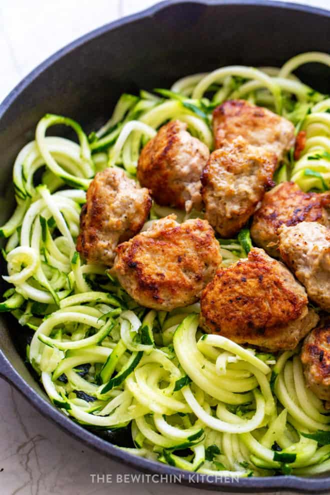 healthy chicken meatballs with zucchini noodles in a cast iron skillet