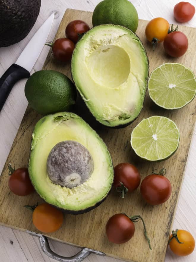 avocados and tomatoes on a cutting board