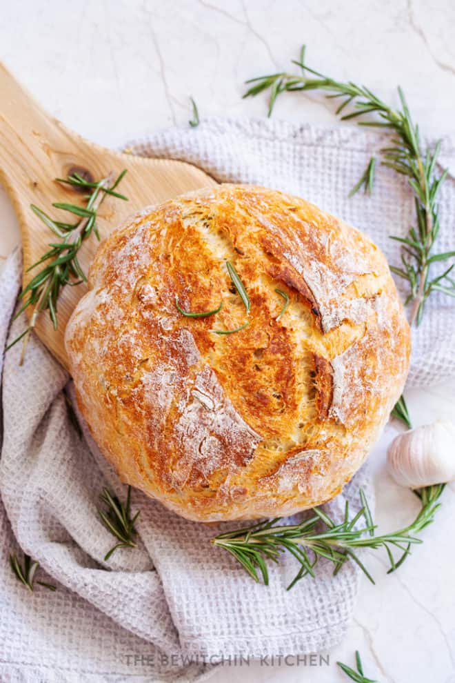 A fresh loaf of homemade rosemary bread baked in a dutch oven