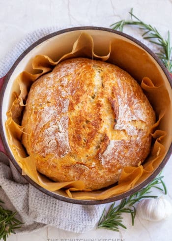 rosemary garlic bread in a dutch oven lined with parchment paper