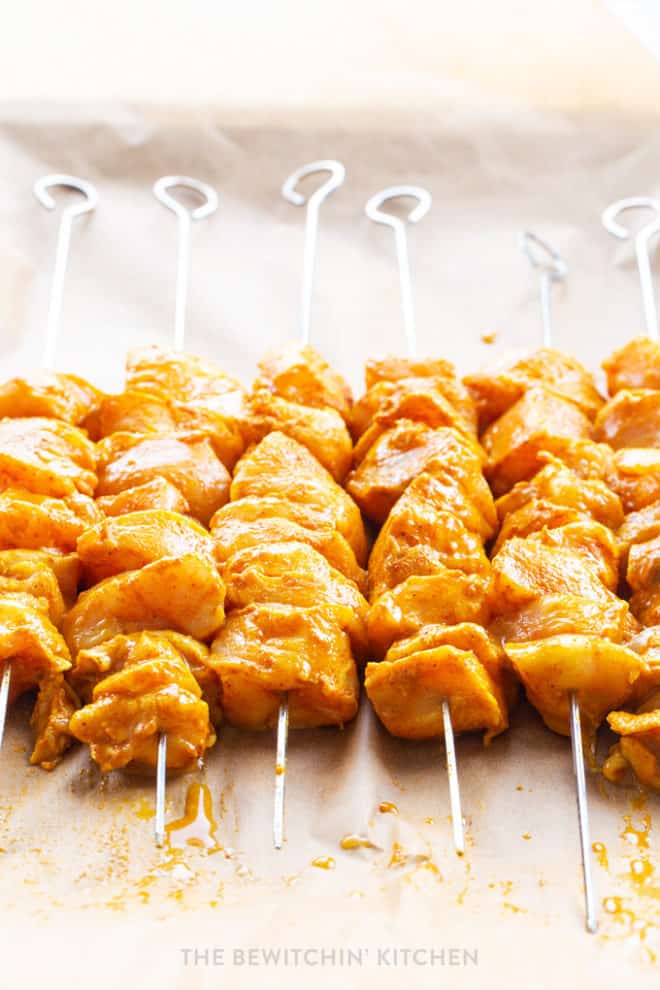 raw chicken cut into cubes and skewered onto kebabs with a curry marinade