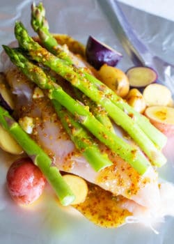asparagus with chicken, honey mustard, chicken and potatoes on top of foil