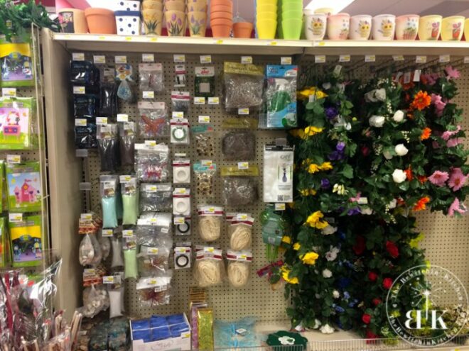 dollar store wall filled with fake floral and crafting supplies for to make a candy bouquet