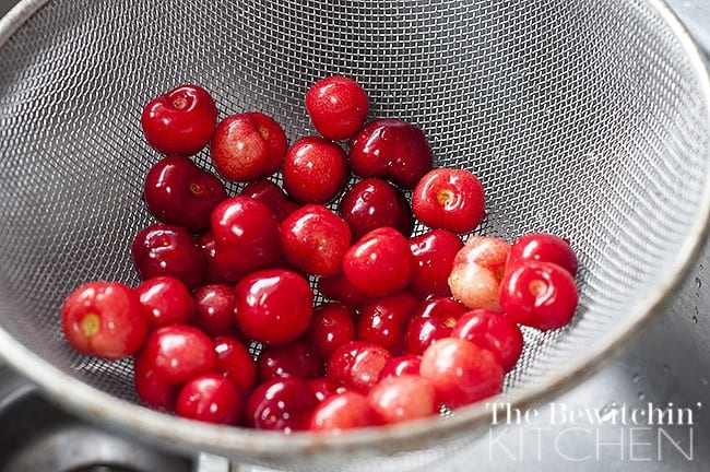 rinsing fresh cherries in a mesh colander