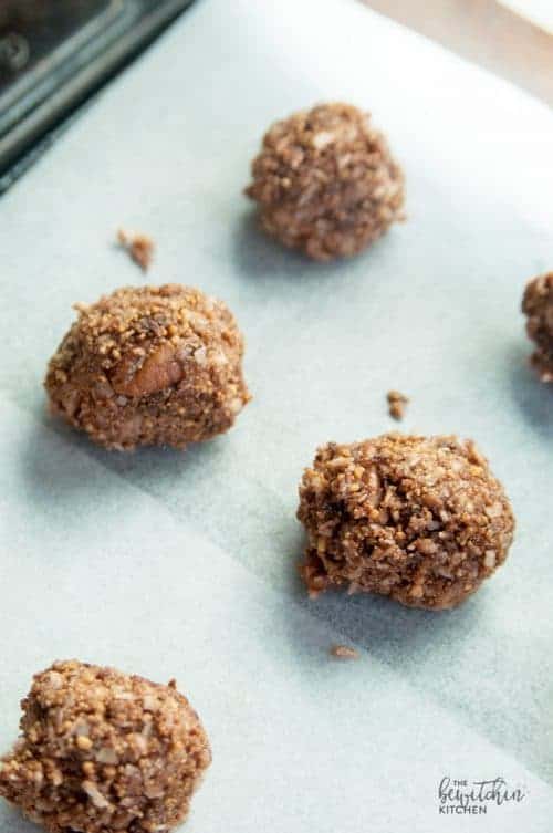 nanaimo coconut balls on a parchment lined pan