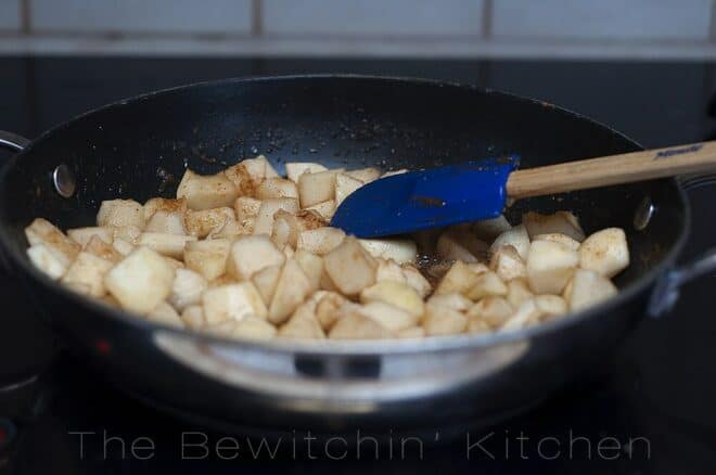 cooking chopped pears in a skillet on the stove