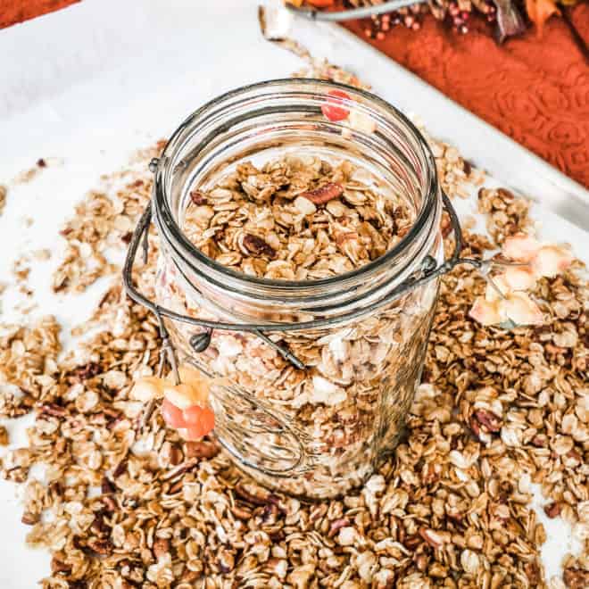 maple pecan granola in and around an open mason jar