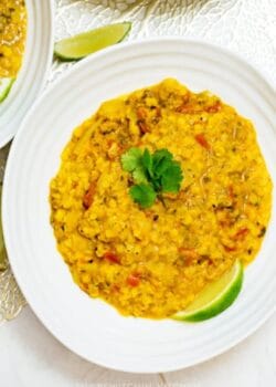 overhead of coconut lentil soup with lime and cilantro garnish