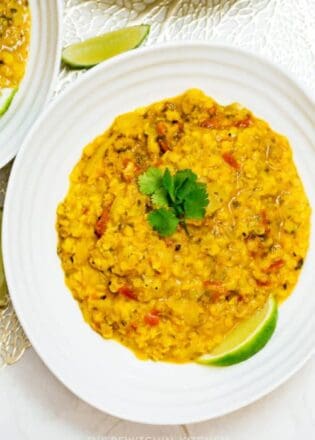 overhead of coconut lentil soup with lime and cilantro garnish