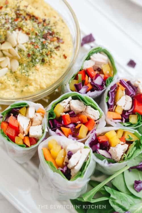 Sliced healthy spring rolls on a serving platter with garlic turmeric dipping sauce