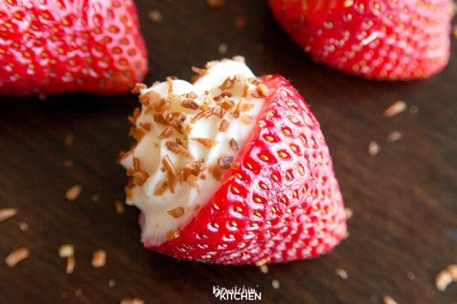 cheesecake filled strawberries on a brown table