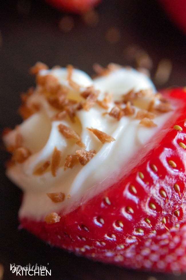 extreme close up of deviled strawberries showing texture of cream cheese filling and toasted coconuts