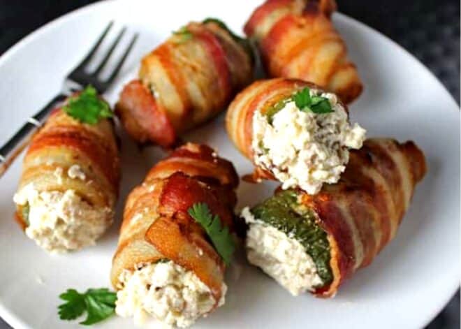 Grilled Stuffed Jalapeños wrapped in bacon, on a plate 