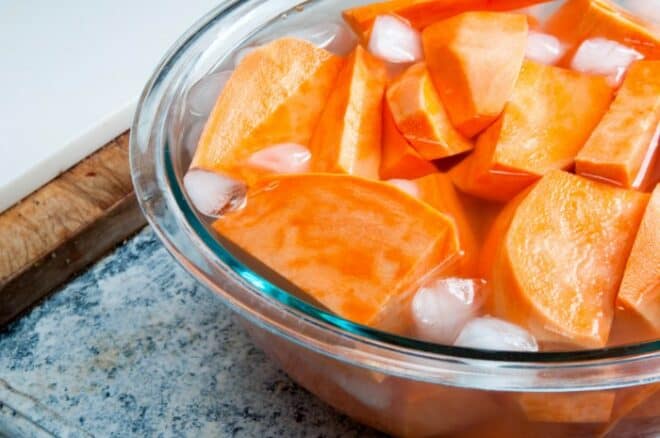 yams soaking in an ice bath to serve with Jamaican jerk chicken