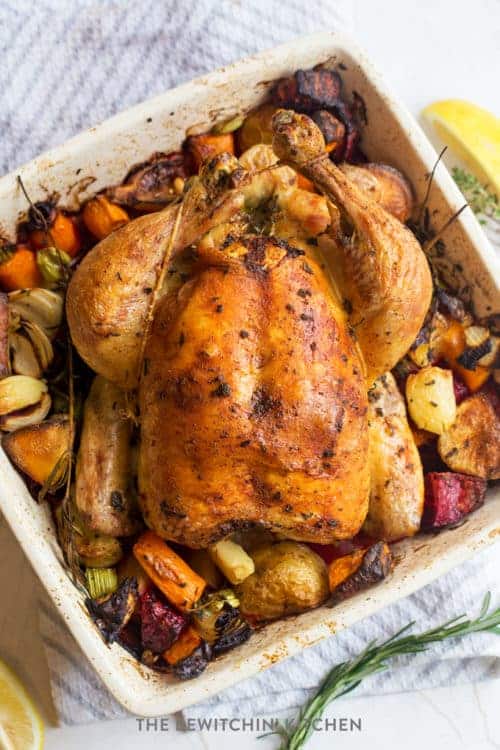 top view of a finished oven roasted whole chicken and potatoes