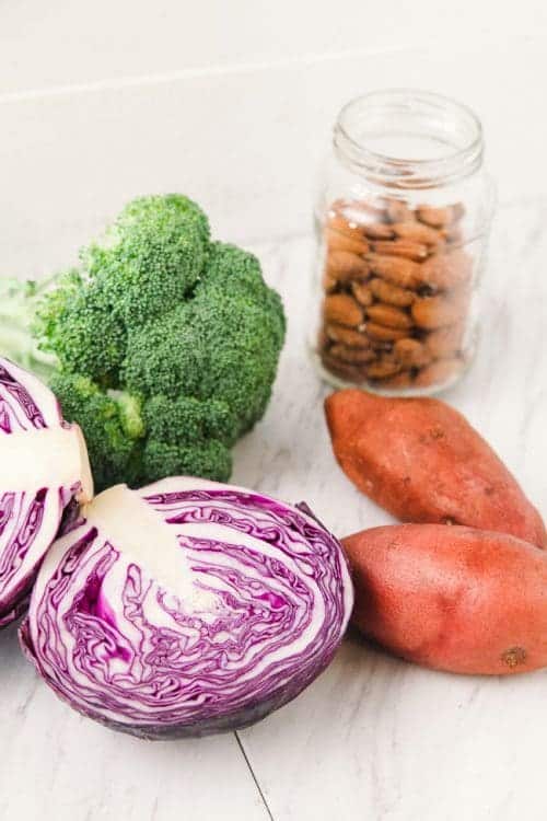 Paleo bowl ingredients including cabbage, sweeet potato, broccoli, and almonds