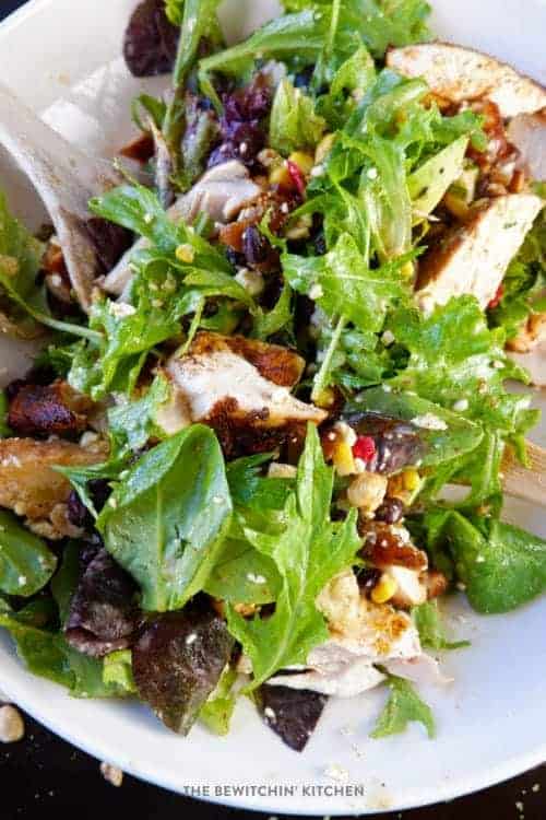 Santa Fe salad with dressing in a white bowl with a silver fork.