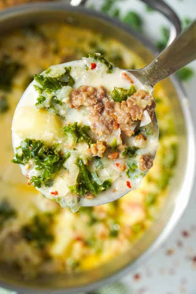 Close up of a ladle full of zuppa toscana soup. 