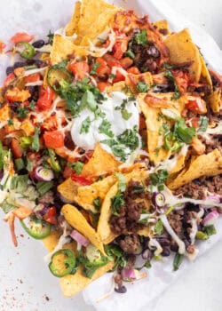 Overhead of air fryer nachos and sour cream