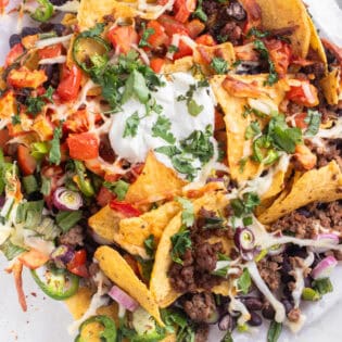 Overhead of air fryer nachos and sour cream