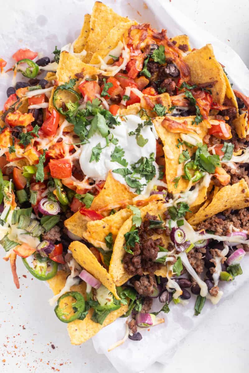 Overhead of air fryer nachos and sour cream