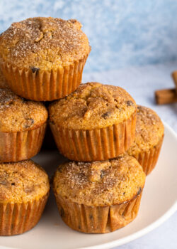 Stack of gluten free pumpkin muffins with cinnamon sticks in the background