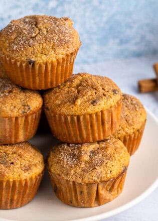 Stack of gluten free pumpkin muffins with cinnamon sticks in the background