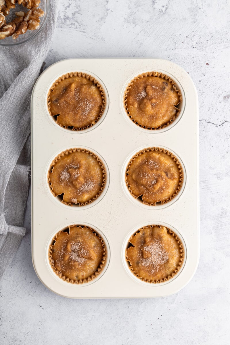 Muffin tray filled with gluten free pumpkin muffin batter