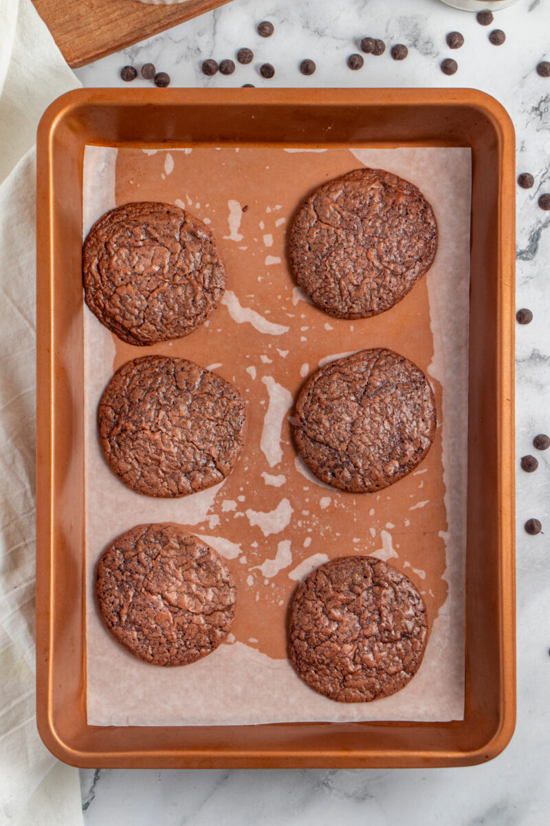 Overhead of 6 brownie cookies on a baking sheet