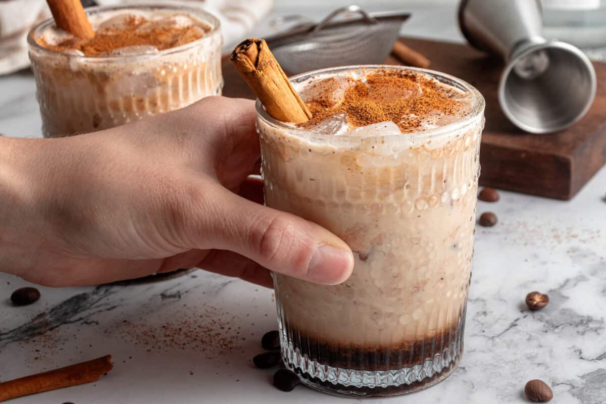 Hand holding a glass of pumpkin spice white Russian