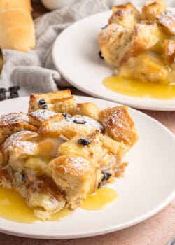 Two servings of bread pudding with rum sauce