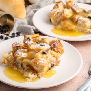 Two servings of bread pudding with rum sauce
