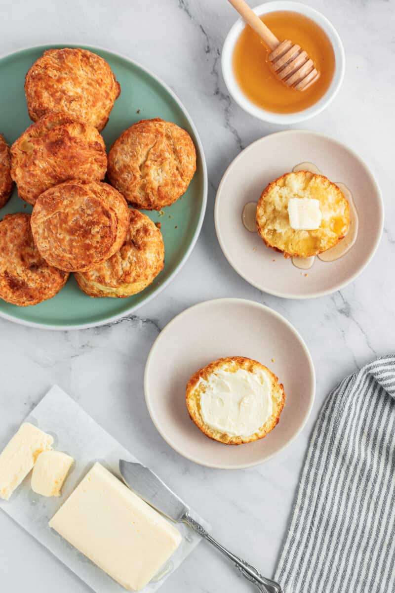 Overhead of air fryer biscuits served with butter and honey