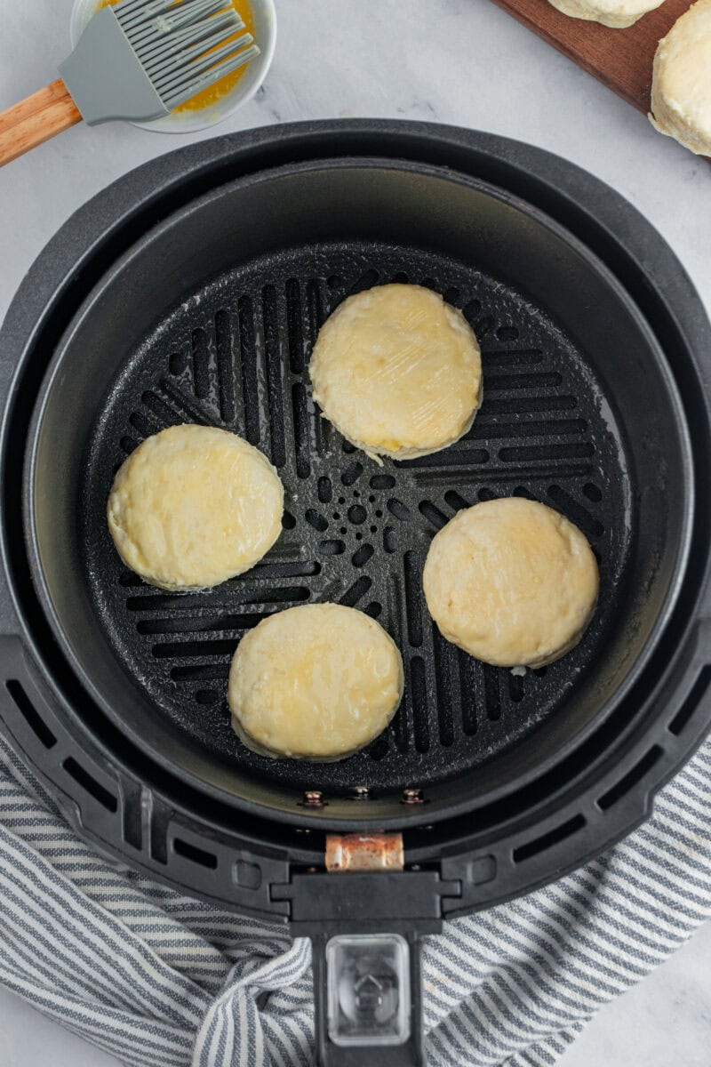 Four biscuits cooking in the air fryer